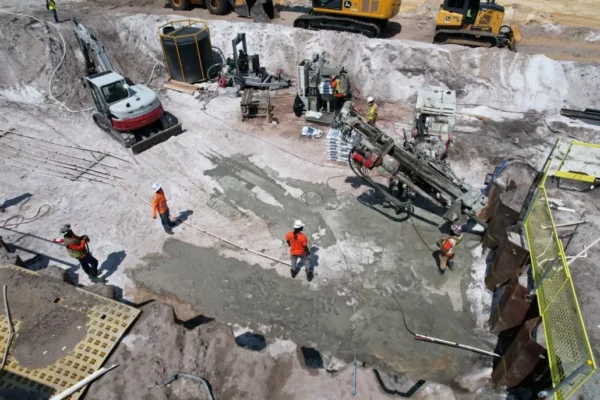 Aerial view of workers and machines at a sandy site.