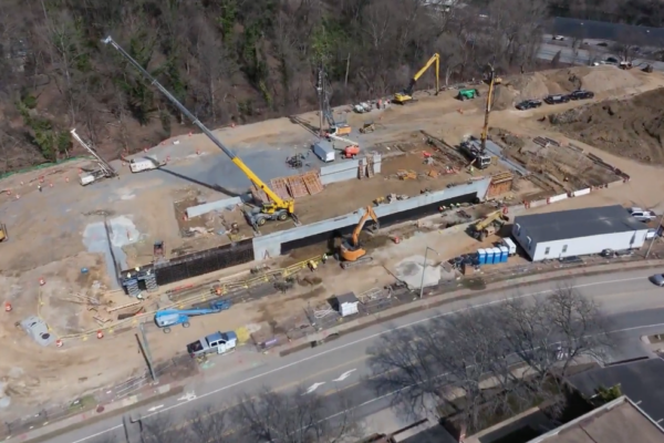 Aerial view of construction site with cranes and workers.