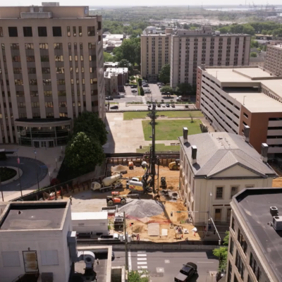 Aerial view of city construction site amid offices and parking.