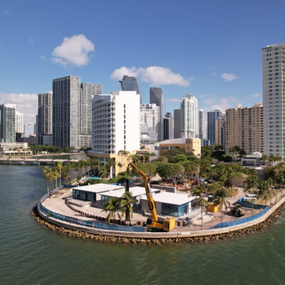 Waterfront construction, palm trees, water, and high-rises.