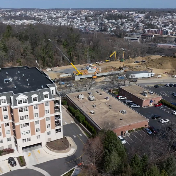 Aerial view of cranes at a building site beside apartments.