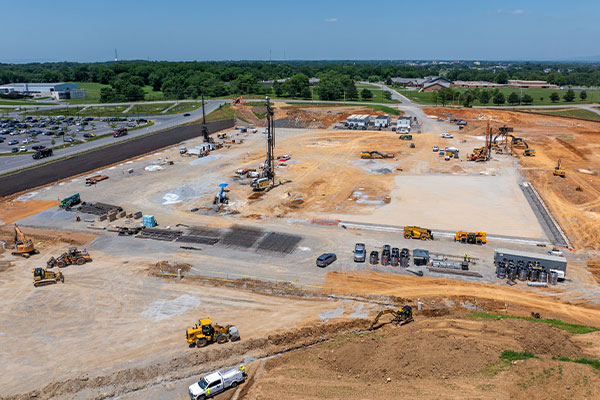 Aerial shot of construction site with machinery, vehicles, and materials.