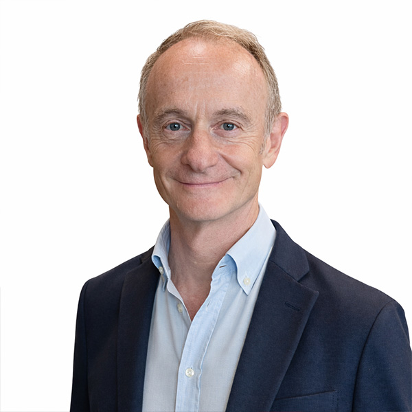 Smiling middle-aged man in blue blazer and shirt on white.