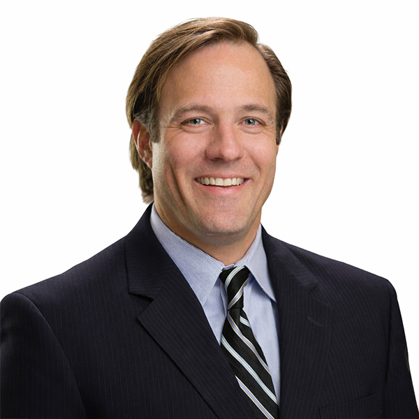 Smiling man in suit and tie on a white background.