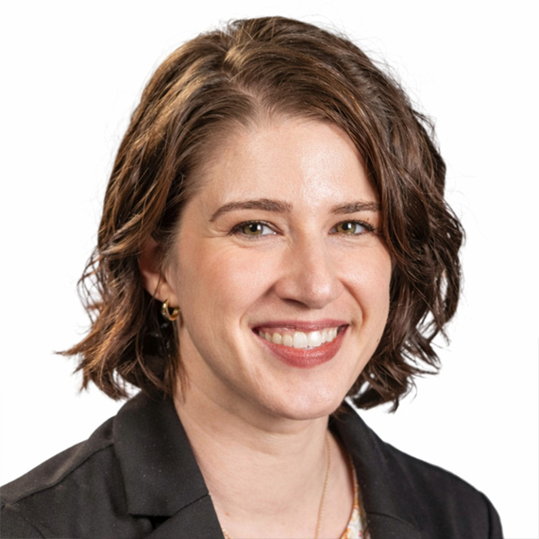 Smiling woman with short brown hair in black blazer on white.