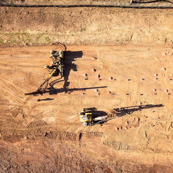Aerial view of two construction vehicles on a dirt site.